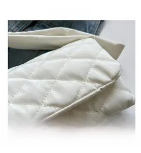Gros plan détaillé du sac en nylon matelassé blanc avec surpiqûres en losange et texture douce