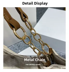 Détail de la chaîne en métal doré sur un grand sac fourre-tout en daim gris clair