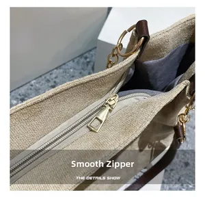 Détail de la fermeture éclair dorée lisse sur un sac cabas en daim beige chic