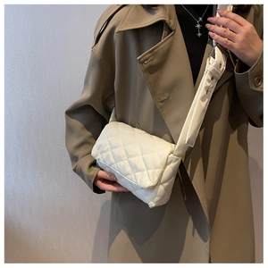 Détail du sac bandoulière matelassé beige avec sangle large et boucle métallique