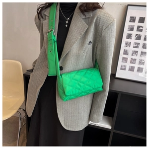 Détail d'un sac bandoulière matelassé vert vif avec large bandoulière réglable