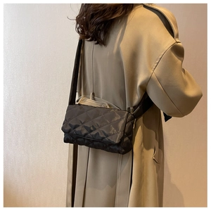 Vue arrière d'un modèle portant un sac bandoulière en nylon matelassé noir à sangle large