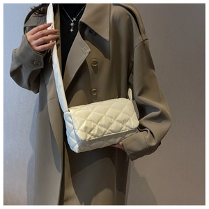Gros plan du sac à bandoulière matelassé blanc en nylon avec rabat porté sur un manteau