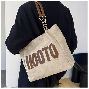 Détail du grand sac cabas beige HOOTO avec bandoulière en cuir marron et chaîne