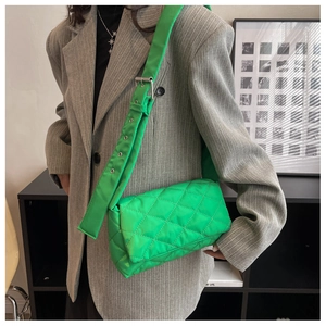 Détail d'un sac bandoulière en nylon matelassé vert vif avec large bandoulière réglable
