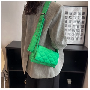 Détail du sac bandoulière en nylon matelassé vert vif avec large sangle à œillets