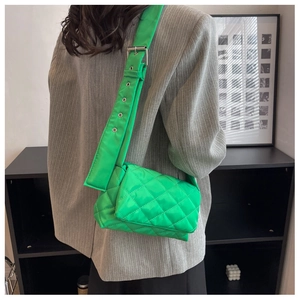 Détail du sac bandoulière en nylon matelassé vert avec large sangle à boucle métallique
