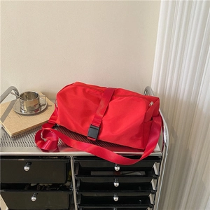 Red high-capacity waterproof fitness duffel bag with adjustable strap on a trolley