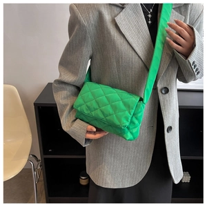 Gros plan sur le sac bandoulière en nylon vert vif avec surpiqûres en losanges matelassés