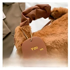 Detail showing the brown plush faux fur texture and ruched leather handle of the handbag