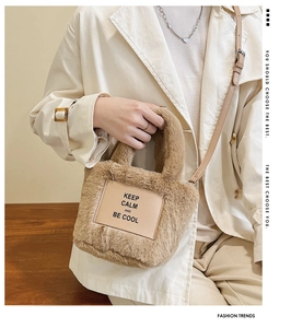Detailed view of plush brown bucket bag with leather patch and adjustable shoulder strap