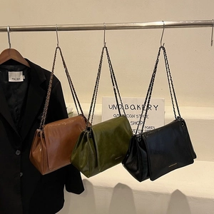 Three minimalist large-capacity tote bags in brown, black, and green with chain straps