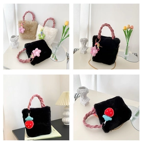 Détail du sac seau en peluche avec poignées tressées et breloque florale