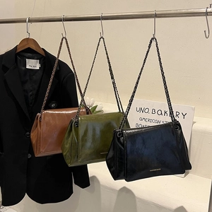 Three large soft leather tote bags in black, green, and brown with retro chain straps