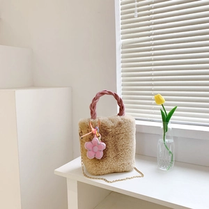 Détail du sac cabas en peluche avec poignée tressée rose et breloque fleurie sur chaîne dorée