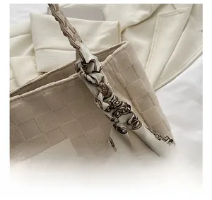 Close-up of beige woven tote bag with silk scarf accessory and fashion leather label