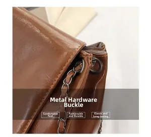 Macro shot of dark brown soft leather bag with gunmetal ring and chain strap detail