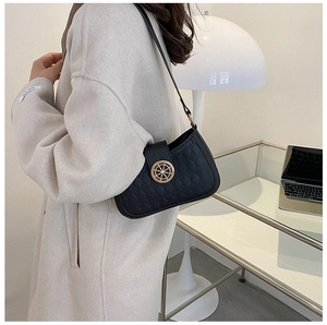 Detail of black quilted leather shoulder bag featuring a gold rudder-shaped lock closure