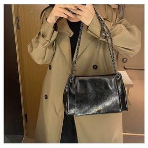 Detail of a black glossy chain shoulder bag featuring the Fashion logo and metal strap