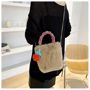Détail du sac seau en fausse fourrure pelucheuse avec anse rose et breloque fraise