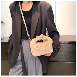 Detailed view of apricot plush handbag featuring soft fur texture and stylish chain strap