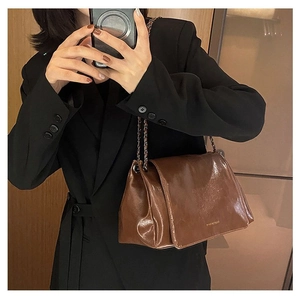 Mirror selfie showing the medium-sized dark brown leather tote with a gold chain strap