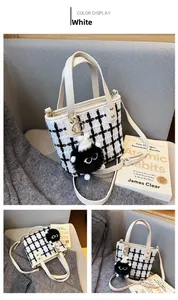 Close-up of black and white tweed bucket bag texture with a cute plush monster charm