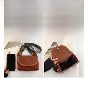 Detailed view of crossbody bag size and internal compartments with ethnic strap