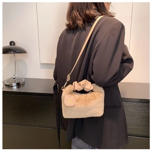 Detail of beige faux fur crossbody bag with leather pleated handle and gold chain