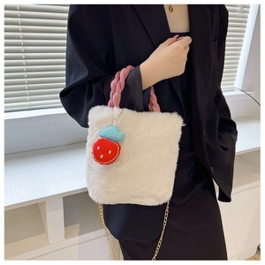 Détail du sac seau en peluche blanche avec poignée torsadée rose et pendentif fraise