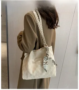 Close-up of cream woven tote bag featuring a geometric silk scarf and fashion leather patch