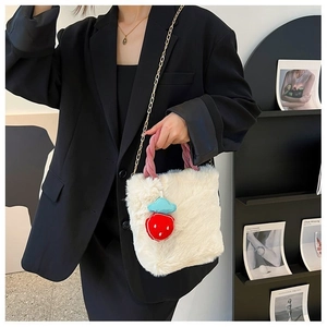 Détail du sac seau en fausse fourrure blanche avec anse tressée rose et fraise rouge