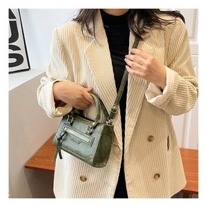 Dettaglio della borsa moto vintage verde scuro in pelle testurizzata con nappe