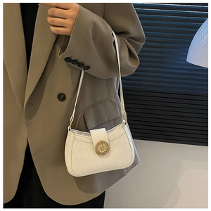 Detailed view of white quilted faux leather shoulder bag with golden hollow buckle