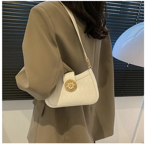 Detail of white quilted crossbody bag with a round gold buckle on a neutral background