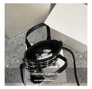 Internal capacity of black and white tweed bucket bag showing makeup storage