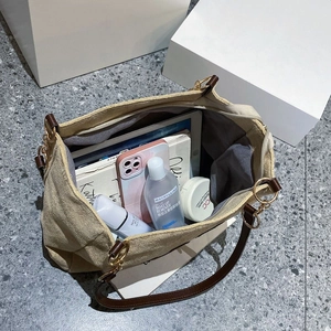 Grand sac fourre-tout beige avec anses brunes offrant un rangement pour tablette