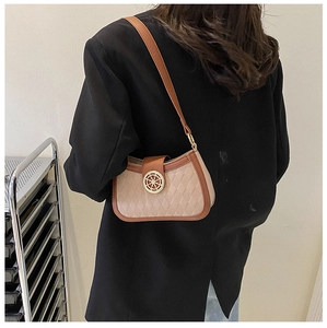 Detail of a chic shoulder bag with beige quilting and a gold steering wheel clasp detail