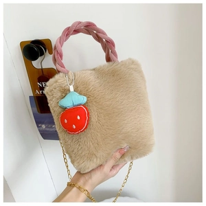 Détail du sac seau en peluche avec poignée tressée rose et bijou de sac fraise
