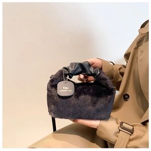 Detail of black faux fur handbag featuring soft texture and pleated cloud handle