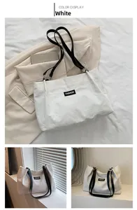 Detail of white corduroy tote bag with black Fashion label and durable shoulder straps