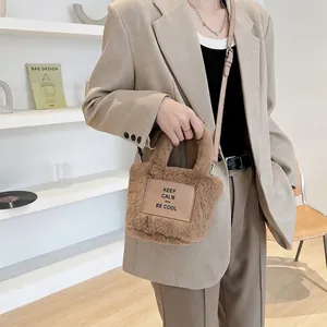 Brown fuzzy faux fur bucket bag with leather patch and adjustable strap for women
