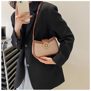 Close-up of stylish two-tone shoulder bag featuring quilted pattern and golden clasp