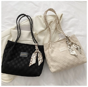Close-up of quilted woven tote bags with decorative silk scarf and fashion leather label