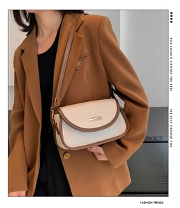 Close-up of contrast color crossbody bag with cream leather and brown trim details