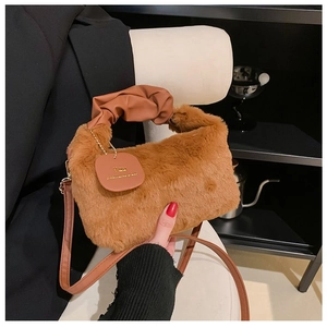 Detail of plush brown shoulder bag with faux fur texture and pleated leather handle
