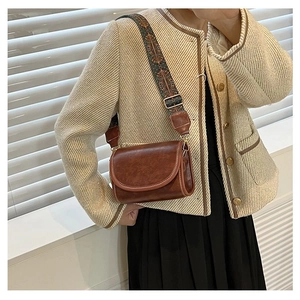 Detailed view of vintage brown crossbody bag with ethnic style jacquard strap