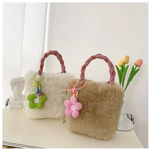 Vue détaillée de sacs seaux en fausse fourrure douce avec poignées roses tressées et breloques