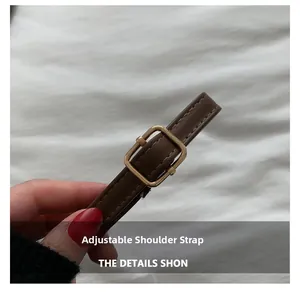 Close-up of brown leather adjustable shoulder strap with premium gold square buckle