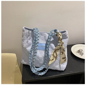 Detail of light blue woven tote bag with silk scarf and Fashion & Bags label